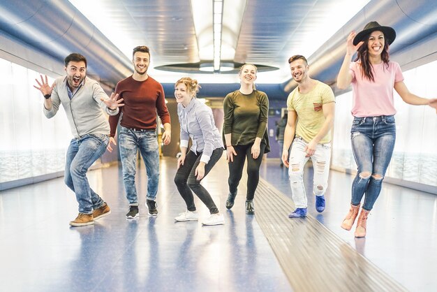 Foto longitude completa de amigos felizes na estação de metrô