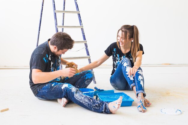 Foto longitude completa de jovem feliz sentada contra a parede azul