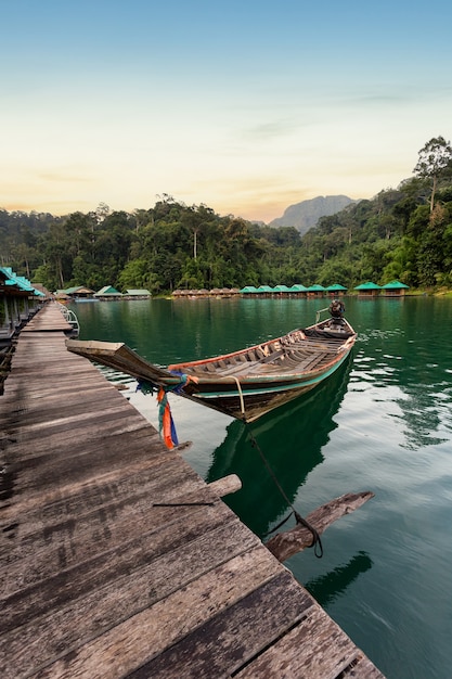 Longtail-Boot mit schöner Aussicht auf einen Pier an einem See