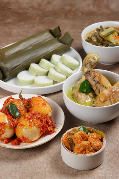 Lontong Lebaran serviert mit Sambal Goreng opor ayam sayur labu siam rendang und telur balado