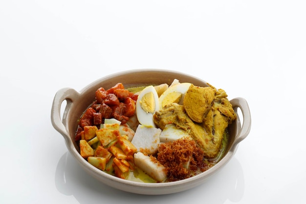 Lontong Opor, pequeno-almoço tradicional indonésio ou um menu Eid. Opor feito de Frango Cozido com Leite de Coco e Especiarias. Serviu para celebrar o Eid Adha e o Eid Fitr. Isolado em Branco