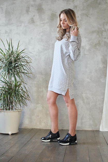 Lookbook. Chica elegante sobre fondo de pared gris