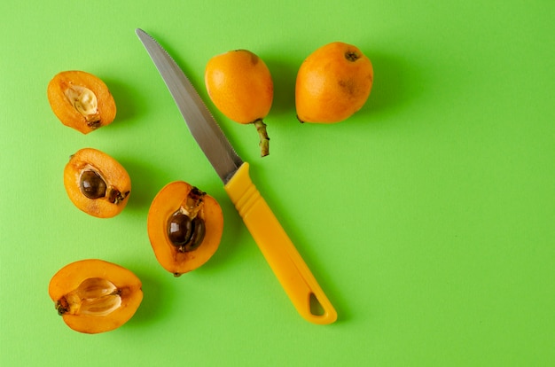 Loquats e nkife frescos maduros no verde