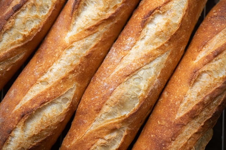 Foto un lote de baguettes recién horneadas en el fondo de cerca
