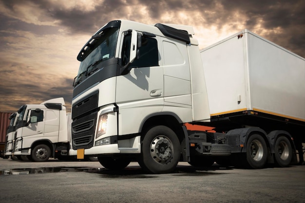 Lote estacionado de caminhões semi-reboque com o Sunset Sky Caminhão a diesel Caminhão de carga Transporte logístico