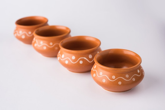 Louça de terracota vazia ou conjunto de jantar como prato, tigela de sopa, tigela de servir, vidro feito de argila marrom, isolado sobre o branco