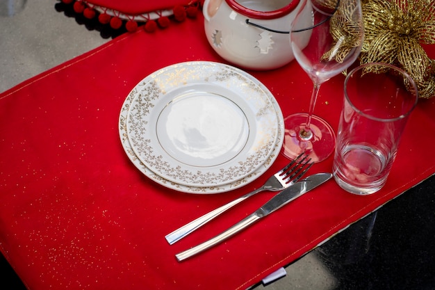 Louças com talheres montadas em mesa com decoração de natal para a ceia de natal