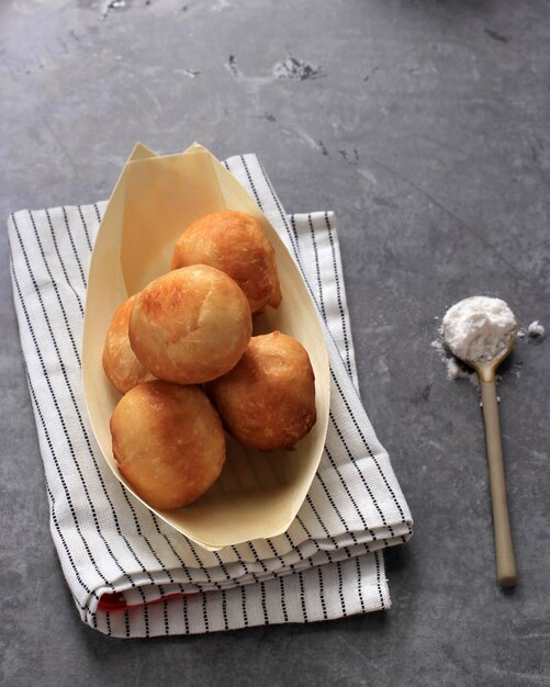 Loukoumades, luqaimat ou lokma em Placa sobre fundo cinza de concreto. Loukoumades são donunts da culinária oriental populares durante o Ramazan. Comida popular do Ramadã. Doces Iftar e Suhur. Copie o espaço