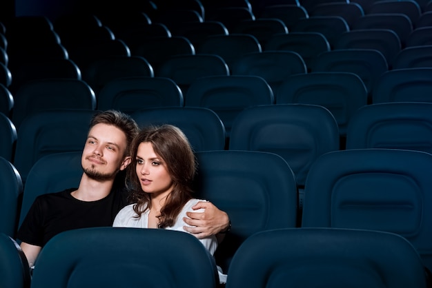 Loving couple assistindo um filme no cinema vazio