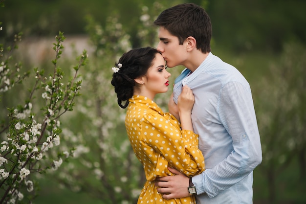 Loving jovem casal em jardim em flor