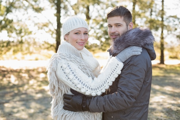 Loving jovem casal em roupas de inverno na floresta