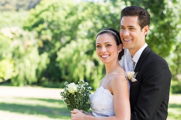 Loving newly wed couple desviando o olhar no parque