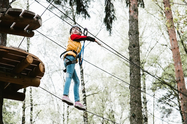 Low-Angle-Ansicht von Mädchen-Zip-Lining im Wald