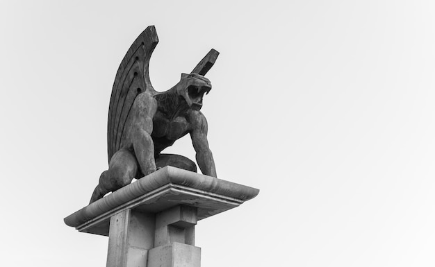 Low Angle Graustufenaufnahme einer Gargoyle-Statue unter einem bewölkten Himmel