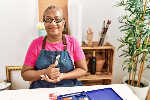 Ältere afroamerikanische Frau, die im Kunststudio mit gehörloser Sprache kommuniziert