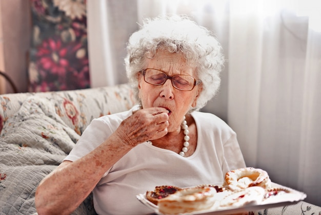 Ältere Dame, die einen Nachtisch schmeckt