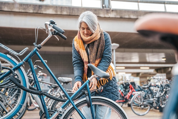 Ältere Frau bekommt das Fahrrad auf einem Parkplatz