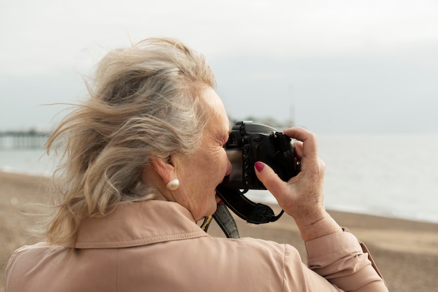 Ältere Frau des mittleren Schusses, die Fotos macht