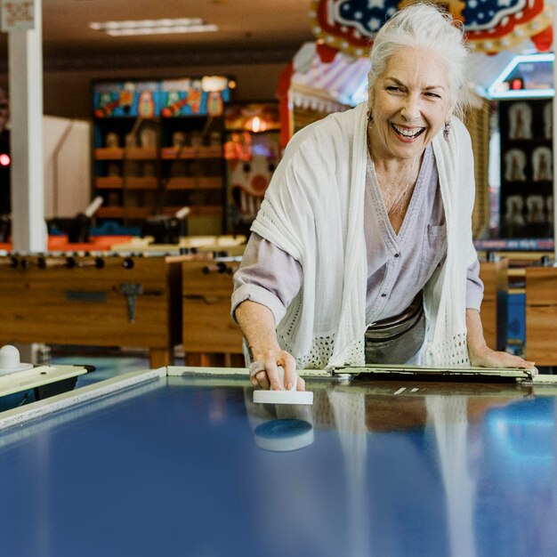 Ältere Frau, die Airhockey spielt