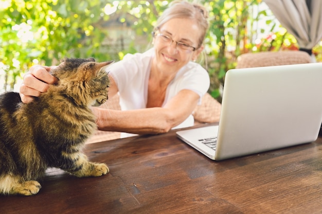 Ältere Frau, die an einem Laptop arbeitet