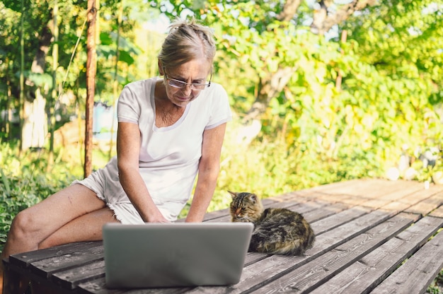 Ältere Frau, die an einem Laptop arbeitet