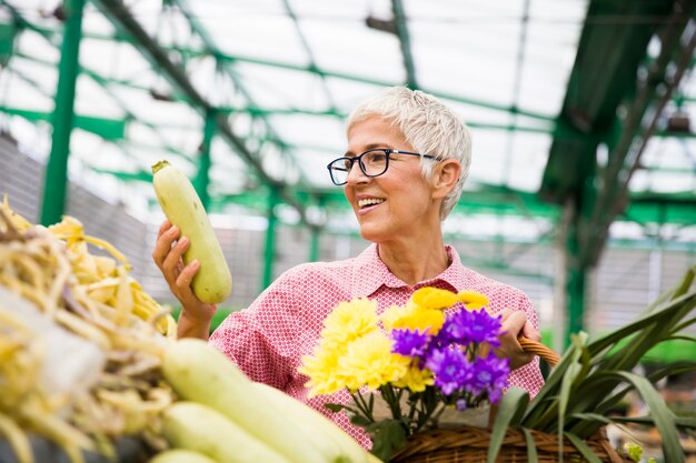 Ältere Frau, die auf Markt kauft