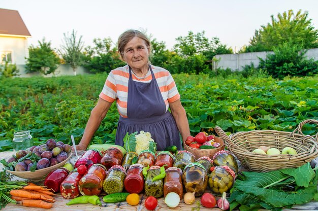 Ältere Frau, die Gemüse in den Gläsern konserviert Selektiver Fokus