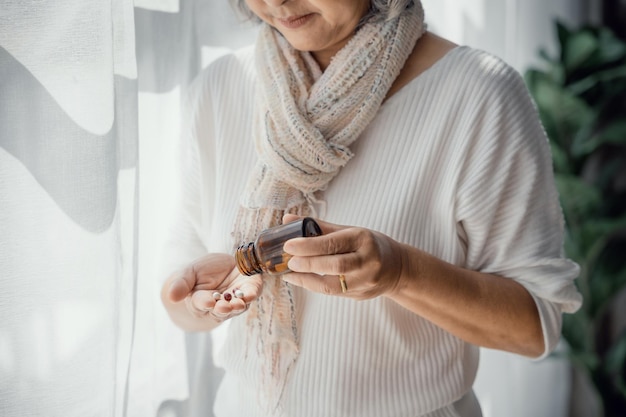 Ältere Frau gießt Kapsel aus Pillenflasche, die Antidepressiva einnimmt Seniorenmedizin medizinisches Behandlungsplankonzept