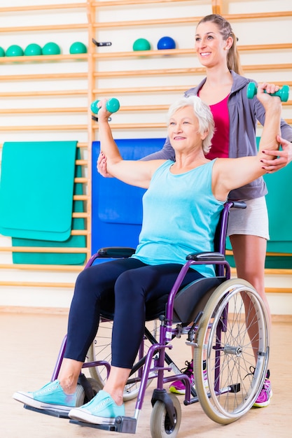 Ältere Frau im Rollstuhl, der Physiotherapie tut