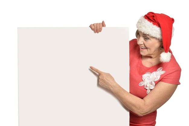 Ältere Frau in der Weihnachtsmannmütze mit weißem Rohling