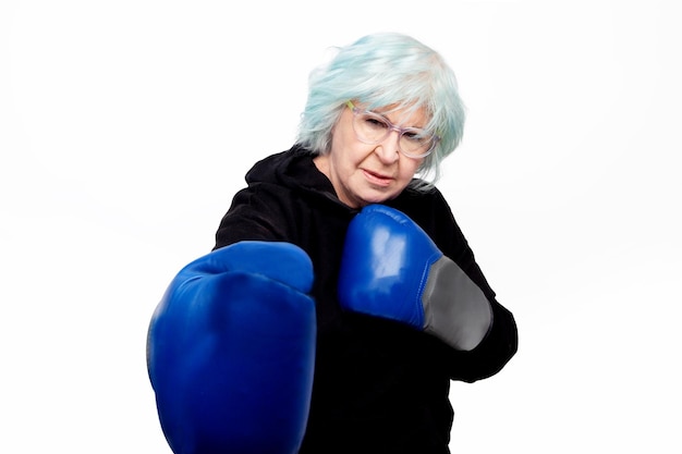Ältere Frau mit Boxhandschuhen und Wachhaltung auf weißem Hintergrund