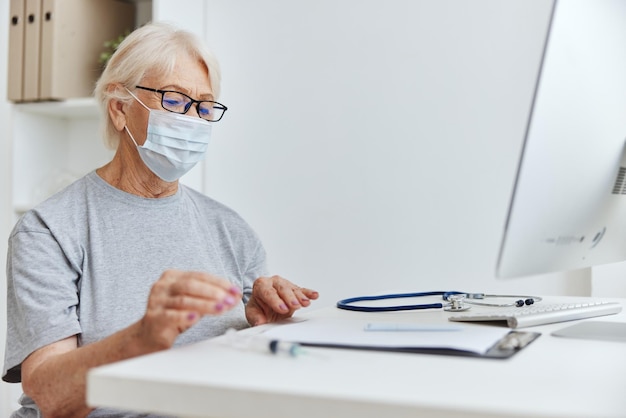 Ältere Frau mit Brille, medizinische Maske, Arzttermin