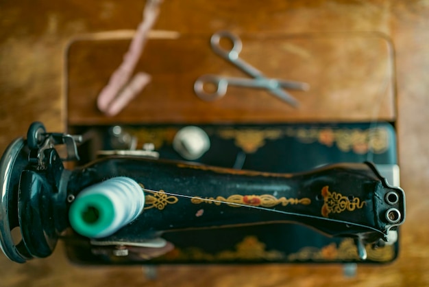 Ältere Frau mit Brille verwendet Nähmaschine faltige Hände der alten Näherinälteren Frau Alte Nähmaschine Klassische manuelle Nähmaschine im Retro-Stil, die für Näharbeiten bereit ist