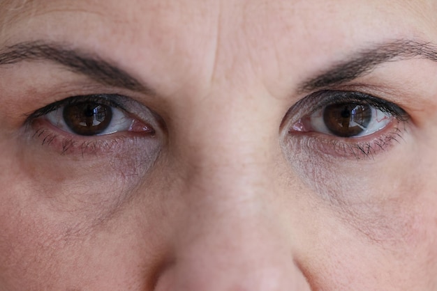 Ältere Frau mit dunkelbraunen Augen und Falten Nahaufnahme Konzept zur Gesundheitsuntersuchung der Sehkraft