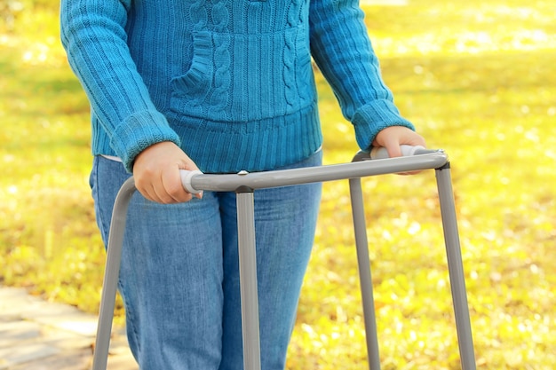 Ältere Frau mit gehendem Rahmen im Park