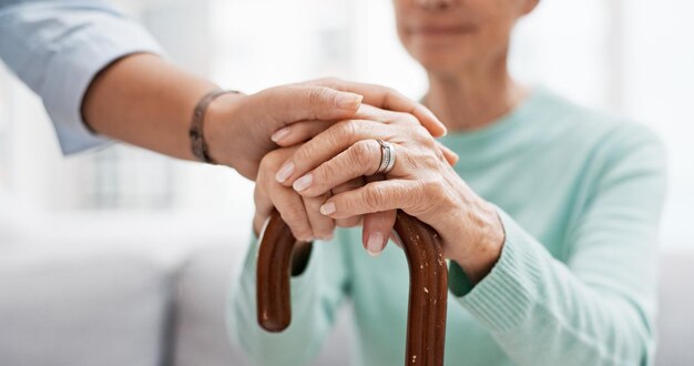 Ältere Frau mit Gehstock und Händchen der Krankenschwester mit Gesundheitsunterstützung für den Ruhestand Pflegekraft ältere weibliche Person und Empathie mit Pflege und Pflege des Patienten mit Hilfe in einem Zuhause