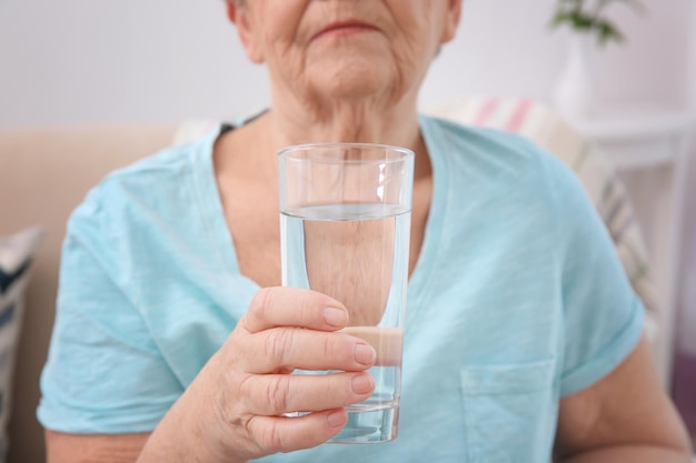 Ältere Frau mit Glas Wasser Nahaufnahme Konzept des Ruhestands