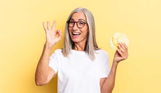 Ältere Frau mit grauen Haaren. Reiskuchen-Konzept