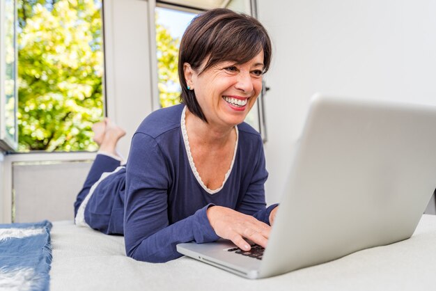 Ältere Frau mit Laptop zu Hause