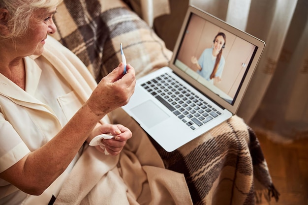 Ältere Frau mit Online-Beratung mit Arzt zu Hause