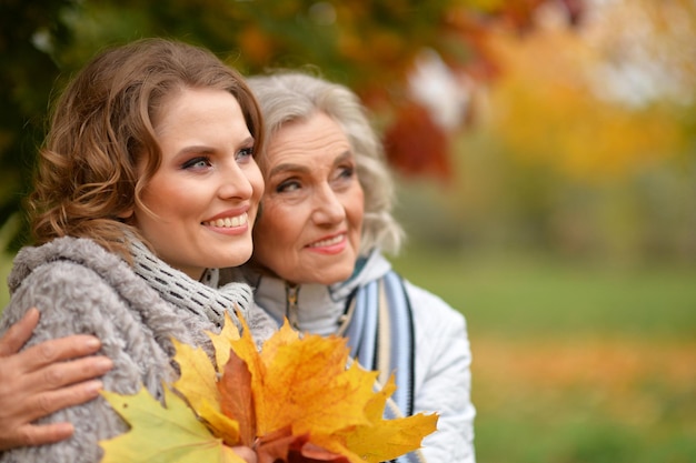 Ältere Frau mit Tochter, die im herbstlichen Park stillsteht