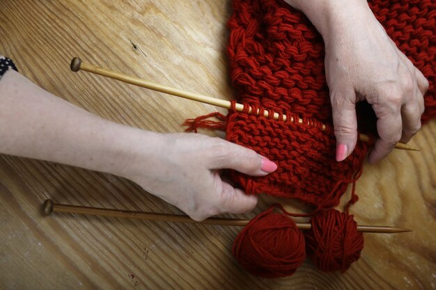 Ältere Frau strickt warme Pullover für ihre Enkel