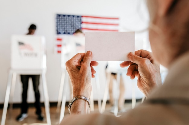 Ältere Frau zeigt Stimmzettel in der Luft