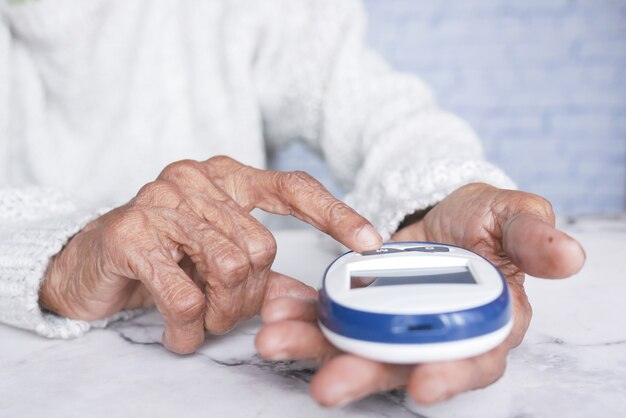 Ältere Frauen mit Diabetes messen den Glukosespiegel zu Hause