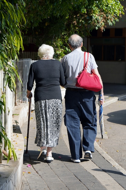 Ältere Frauen und Mann gehen in Park.