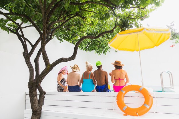 Ältere Freunde bei einer Poolparty im Sommer