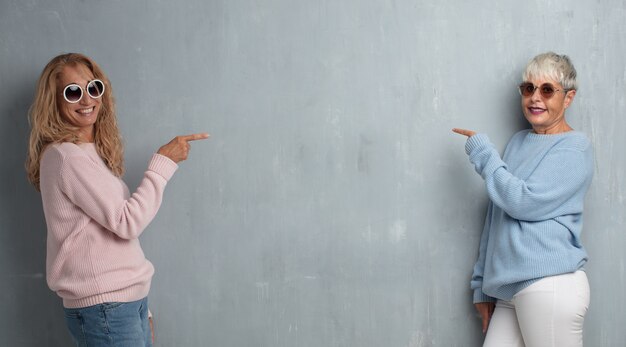 Ältere Freunde der kühlen Frauen gegen Schmutzzementwand.