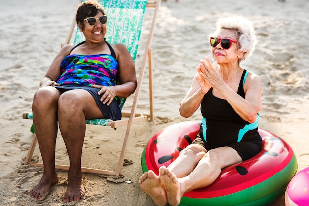 Ältere Freunde, die den Strand in der Sommerzeit genießen