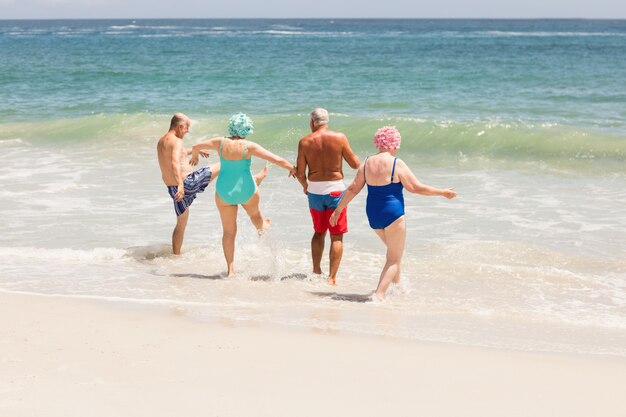 Ältere Freunde, die im Wasser spielen