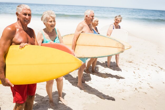 Ältere Freunde, die Surfbrett halten